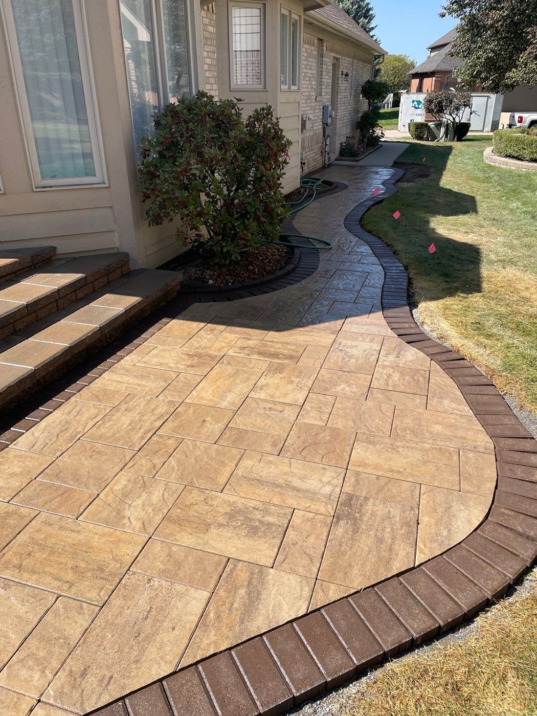 Curved herringbone paver walkway with a border