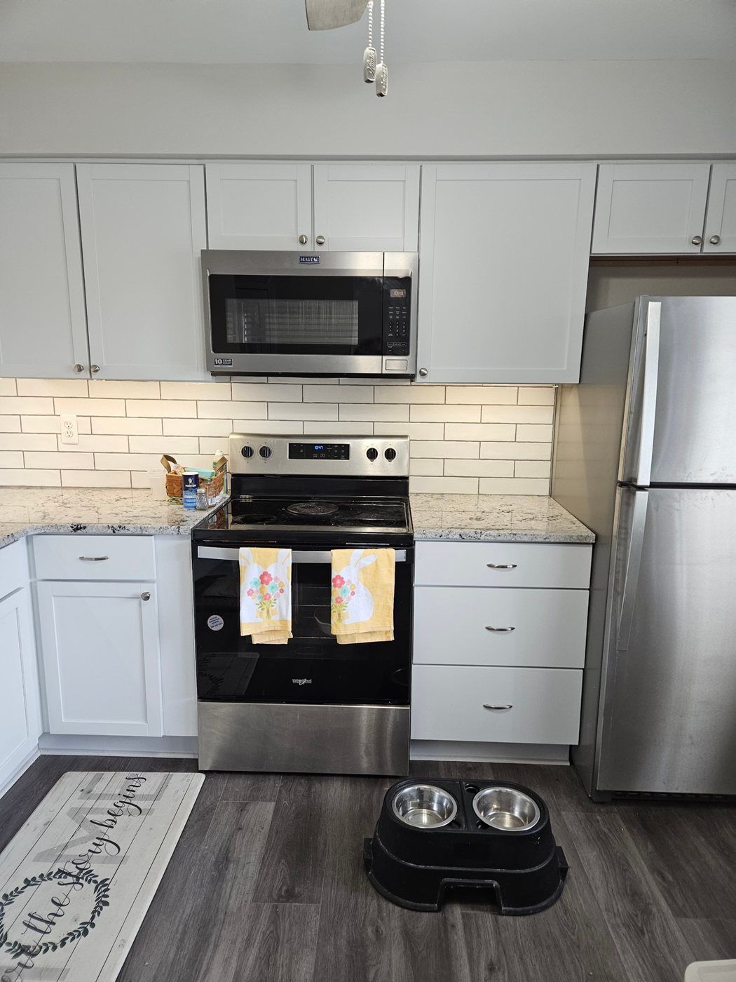 Renovated kitchen with white cabinets and stainless appliances