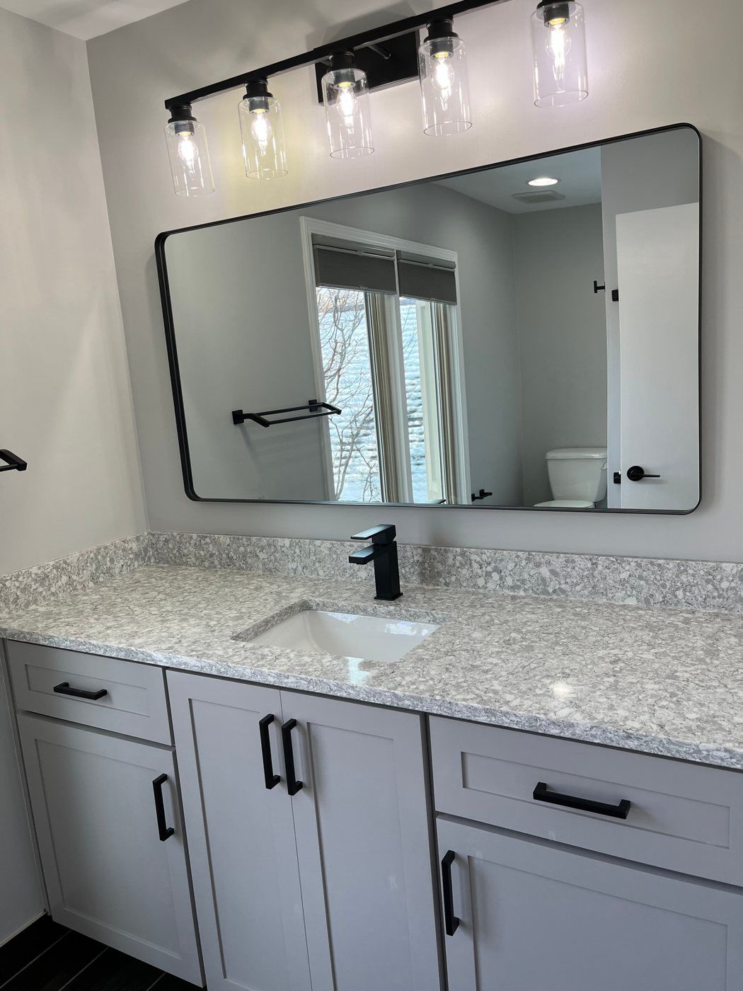Updated bathroom vanity with mirror and black fixtures